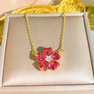 Collana a fiore in acciaio al titanio con zirconi a cuore rosso su un portagioie