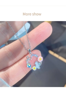 Dettaglio della collana d'argento con ciondolo gatto, ciondoli margherite e perline