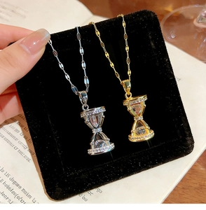 Detalle de los colgantes de reloj de arena en oro y plata con incrustaciones de cristal