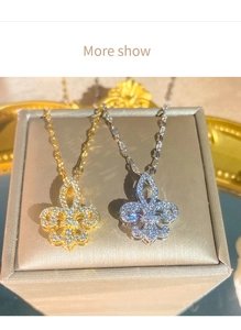 Dettaglio di pendenti a giglio in oro e argento con zirconi in una scatola per gioielli