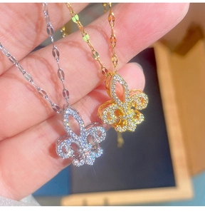 Primo piano di ciondoli a giglio in oro e argento con cristalli di zirconia scintillanti