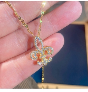 Macro della collana con ciondolo a giglio dorato e pavé di zirconi scintillanti