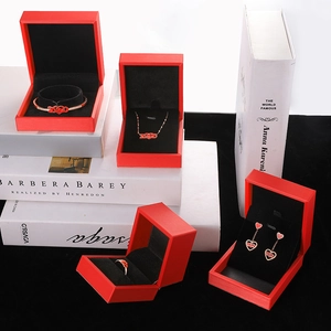 Detalle de set de joyas de corazón en esmalte rojo en cajas de regalo rojas con terciopelo