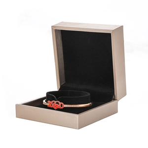 Pulsera de oro rosa con corazón de esmalte rojo y dijes 2020 en una caja de regalo de lujo