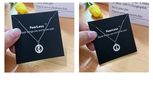 Detailed view of silver pendant necklaces with Eiffel Tower and portrait icons in pavé setting