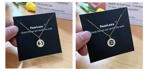 Detail of two gold necklaces with heart and silhouette pendants on black jewelry cards