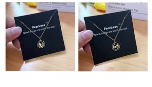 Detailed view of heart and infinity gold pendants on titanium steel chains with card