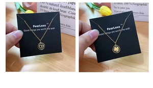 Detail of gold titanium necklaces with heart and clover pendants on display cards