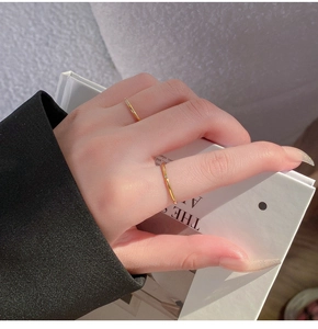 Close-up van minimalistische gouden dunne ringen met fonkelende witte kristallen bij een model