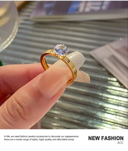 Detailed close-up of a gold-plated six-prong ring featuring a lavender round-cut gemstone