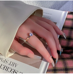 Polished gold titanium ring with a large zircon solitaire shown on a model hand