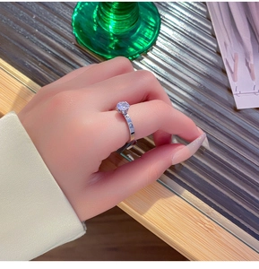 Classic silver titanium ring with six-prong set crystal worn on the finger