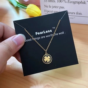 Elegant gold necklace with lucky four-leaf clover pendant on a premium display card