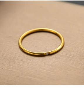 Macro-opname van een minimalistische vergulde titanium ring met een enkele diamant