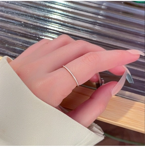 Detalle de un anillo fino de acero de titanio minimalista en un dedo con estilo de lujo