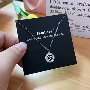 Elegant silver interlocking heart necklace with zircon circles on a black card