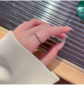 Primer plano de un anillo minimalista dorado con esmalte negro puesto en el dedo