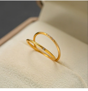 Macro-opname van een minimalistische goudkleurige dubbellaagse ring met zirkoon in een geschenkdoos