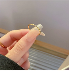 Detailopname van een minimalistische gouden titanium stalen ring met drie diamantjes