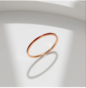 Detalle de un fino anillo de titanio en oro rosa con elegante esmalte rojo