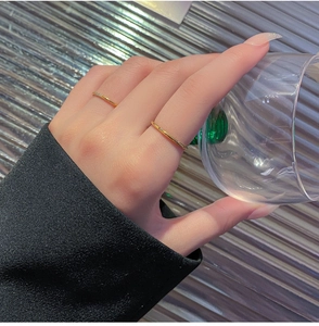 Macro-opname van vergulde minimalistische ringen met kleine diamanten om de vingers