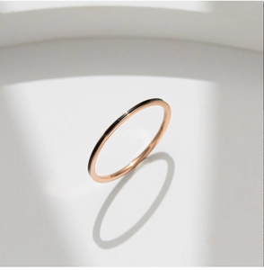 Detalle de anillo fino de titanio en oro rosa con incrustación de esmalte negro y sombra