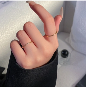 Close-up van elegante minimalistische gouden ringen met kleine diamanten aan vrouwenvingers