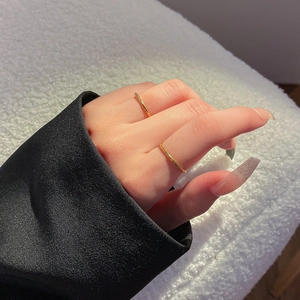 Minimalistische gouden titaniumstalen ringen met kleine diamanten op de hand van het model
