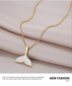 Detail of 18k gold plated fishtail pendant with white pearl enamel inlay on silk