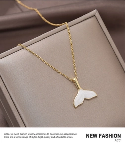Detail of 18k gold plated fishtail pendant with white enamel on a dainty chain necklace