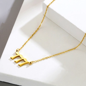 Detailaufnahme des goldenen Anhängers mit Nummer 777 an einer feinen Edelstahlkette