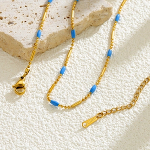 Detail of gold titanium steel necklace with blue beads and S.STEEL engraved tag