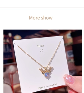 Detail of deer antler heart necklace with crystals on gold chain shown on a card