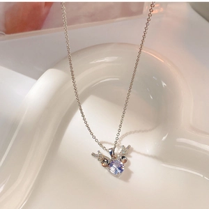 Detailed view of silver deer antler pendant with sparkling cubic zirconia on ceramic tray