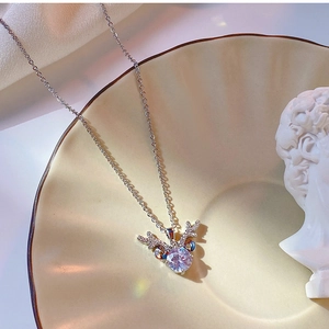 Detailed view of silver antler pendant with zircon on elegant ceramic tray
