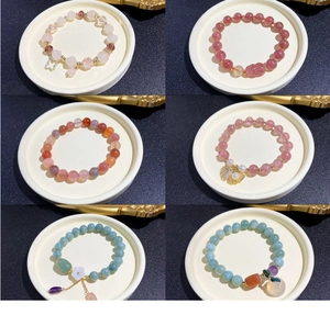 Detail view of six beaded bracelets with natural stones, crystals, and metal pendants