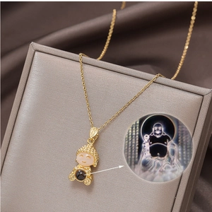 Detail of gold Buddha pendant with projection bead on velvet jewelry box surface