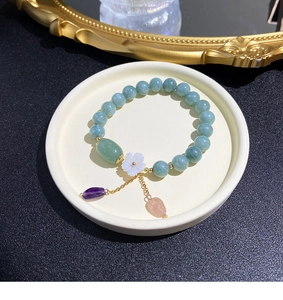 Detail view of natural stone beaded bracelet with flower charm and teardrop gems