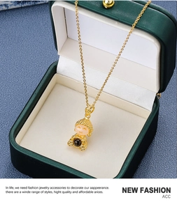Detailed close-up of a gold cartoon Buddha pendant nestled in a green jewelry box