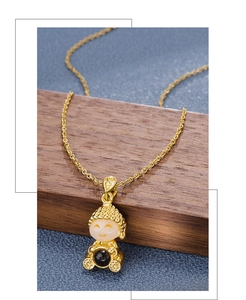 Macro shot of Buddha pendant with white jade texture and black nano projection stone on gold chain