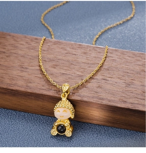 Close-up of golden Buddha pendant with white jade face and elegant gold chain necklace