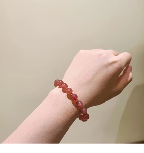 Detail of beaded bracelet featuring 8mm strawberry quartz stones and gold spacers