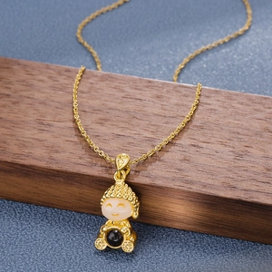 Golden necklace with a cute monk pendant featuring white jade and a dark bead on wood base