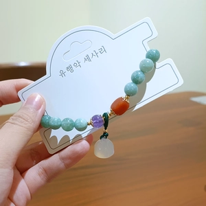Natural stone beaded bracelet with green and pink crystals on elegant display card