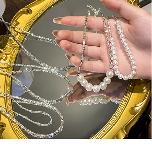 Détail macro du collier ras du cou en perles baroques et fragments de métal argenté