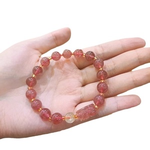 Pink strawberry quartz beaded bracelet with carved PiXiu charm and gold metal accents