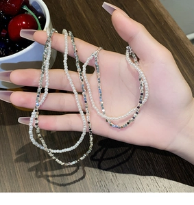 Vue détaillée d'un collier double épaisseur avec perles blanches et perles argentées