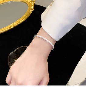 Gros plan d'un bracelet en perles scintillantes au poignet avec des détails argentés