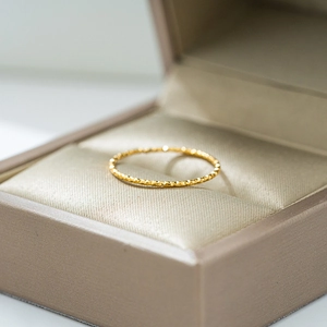 Anillo texturizado ultra fino de oro de 18 quilates con facetas en caja de raso