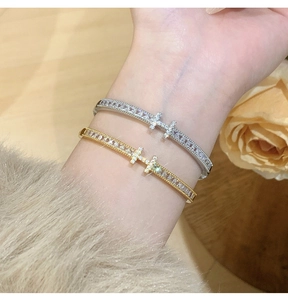 Close-up of gold and silver H-shaped bangles with micro-pave cubic zirconia crystals